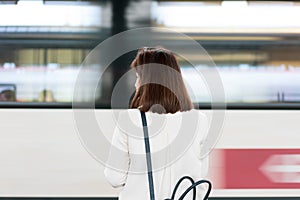 A girl is wating a train in a trian station at Geneva, Switzerland.