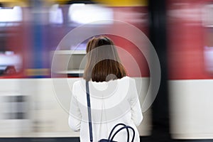 A girl is wating a train in a trian station at Geneva, Switzerland.