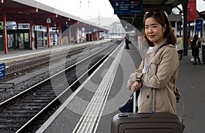 A girl is wating a train in a trian station at Geneva, Switzerland.