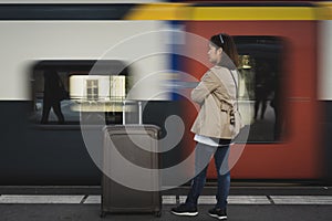 A girl is wating a train in a trian station at Geneva, Switzerland.