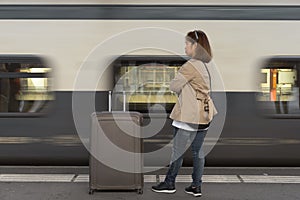 A girl is wating a train in a trian station at Geneva, Switzerland.