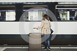 A girl is wating a train in a trian station at Geneva, Switzerland.