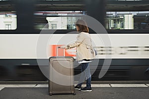 A girl is wating a train in a trian station at Geneva, Switzerland.