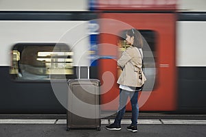 A girl is wating a train in a trian station at Geneva, Switzerland.