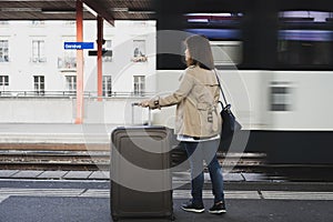 A girl is wating a train in a trian station at Geneva, Switzerland.