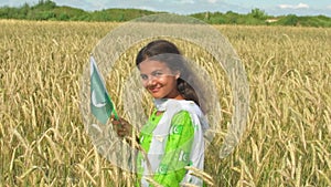 Girl waving flag of Pakistan outdoors . Happy independence day of Pakistan.