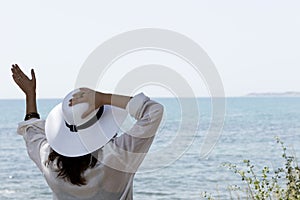 Girl waving in front of the sea