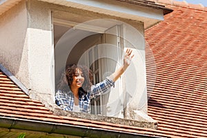 Girl waving hand while looking out the window