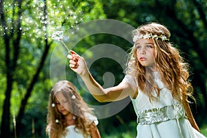 Girl waving magic wand in woods.