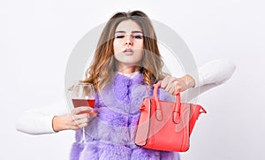 Girl wear fashion fur vest while posing with bag. Luxury store concept. Elite fashion clothes. Lady likes shopping