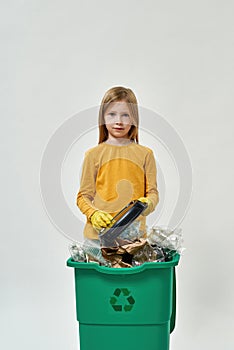 Girl wear gloves hold plastic plate from dustbin