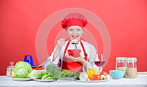 Girl wear hat and apron try meal taste. Woman professional chef hold bowl and spoon. Free healthy vegetarian and vegan