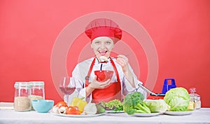 Girl wear hat and apron try meal taste. Woman professional chef hold bowl and spoon. Free healthy vegetarian and vegan