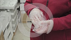Girl wearing against gloves buy glass for strong alcoholic beverages in store