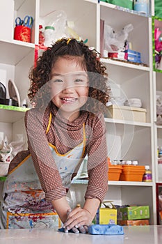 Girl Wearing Apron and Playing with Clay