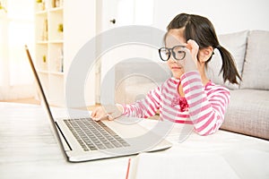 Girl wearing big glasses using her laptop