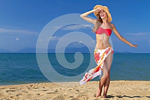 Girl wearing bikini and hat, posing at the beach