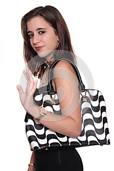 Girl wearing a black dress and a purse smiling and waving goodbye