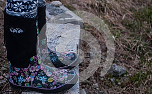 Girl wearing black rubber boots with pink designs