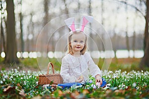 Girl wearing bunny ears playing egg hunt on Easter