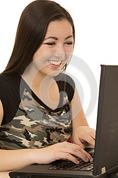 Girl wearing camouflage tee shirt typing on computer