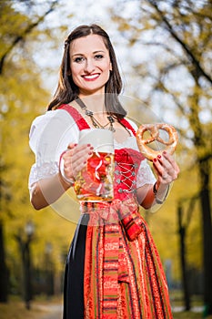 Girl wearing Dirndl with Pretzel and beer mug