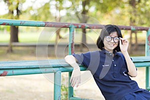 Girl wearing glasses sitting on the bench.