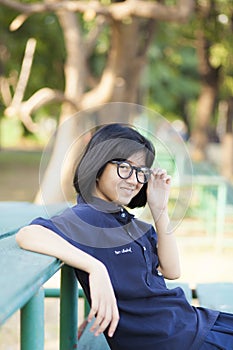 Girl wearing glasses sitting on the bench.