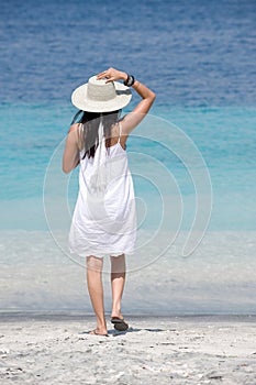 Girl wearing hat enjoying sea breeze photo