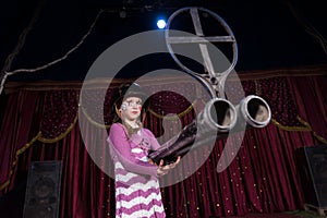 Girl Wearing Helmet Holding Large Gun on Stage