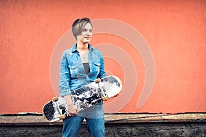 Girl wearing jeans outfit riding a skateboard, isolated on colorful background. Concept of healthy urban lifestyle, hipster