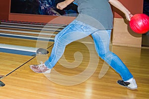 Girl wearing jeans playing bowling.