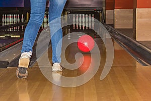 Girl wearing jeans playing bowling.