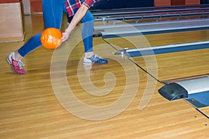 Girl wearing jeans playing bowling.