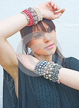 Girl wearing jewelry on both wrists. .