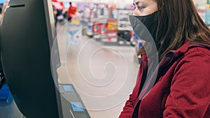 Girl wearing mask against virus buys concave monitor in shop devices