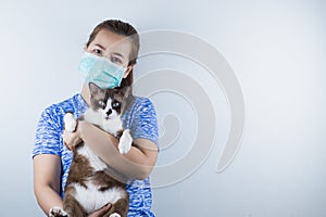 A girl wearing a mask for protecting coronavirus, pm 2.5 and allergic to cat`s fur and she carry a cat. Coronavirus and Air