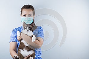 A girl wearing a mask for protecting coronavirus, pm 2.5 and allergic to cat`s fur and she carry a cat. Coronavirus and Air