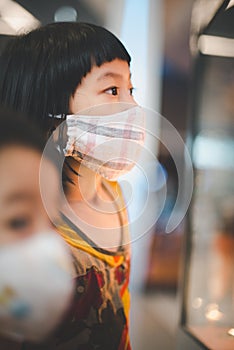 A girl wearing a mask is staring at the showcase.