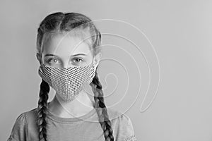 Girl wearing medical face mask on light background, space for text. Black and white photography