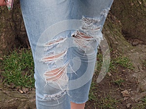 Girl wearing a pair of ripped blue jeans