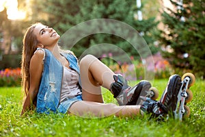 Girl wearing roller skates sitting on grass
