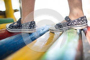 Girl wearing shoes walking on jungle gym