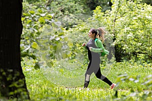 Girl wearing sportswear and running in forest at mountain