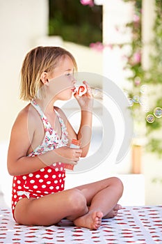 Girl Wearing Swimming Costume Blowing Bubbles