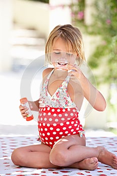 Girl Wearing Swimming Costume Blowing Bubbles