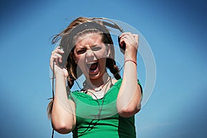 Girl wearing too loud earphone photo