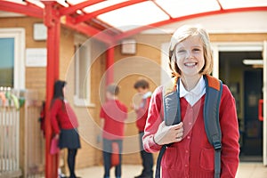 Girl Wearing Uniform Standing In School Playground