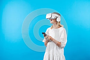 Girl wearing VR glasses while holding phone and pointing at view. Contraption.