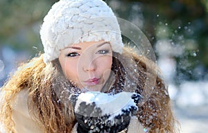Girl Wearing Warm Winter Clothes And Hat Blowing Snow